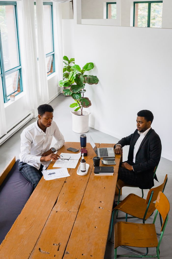Two colleagues collaborate in a bright, minimalist office. Ideal for creative teamwork concepts.